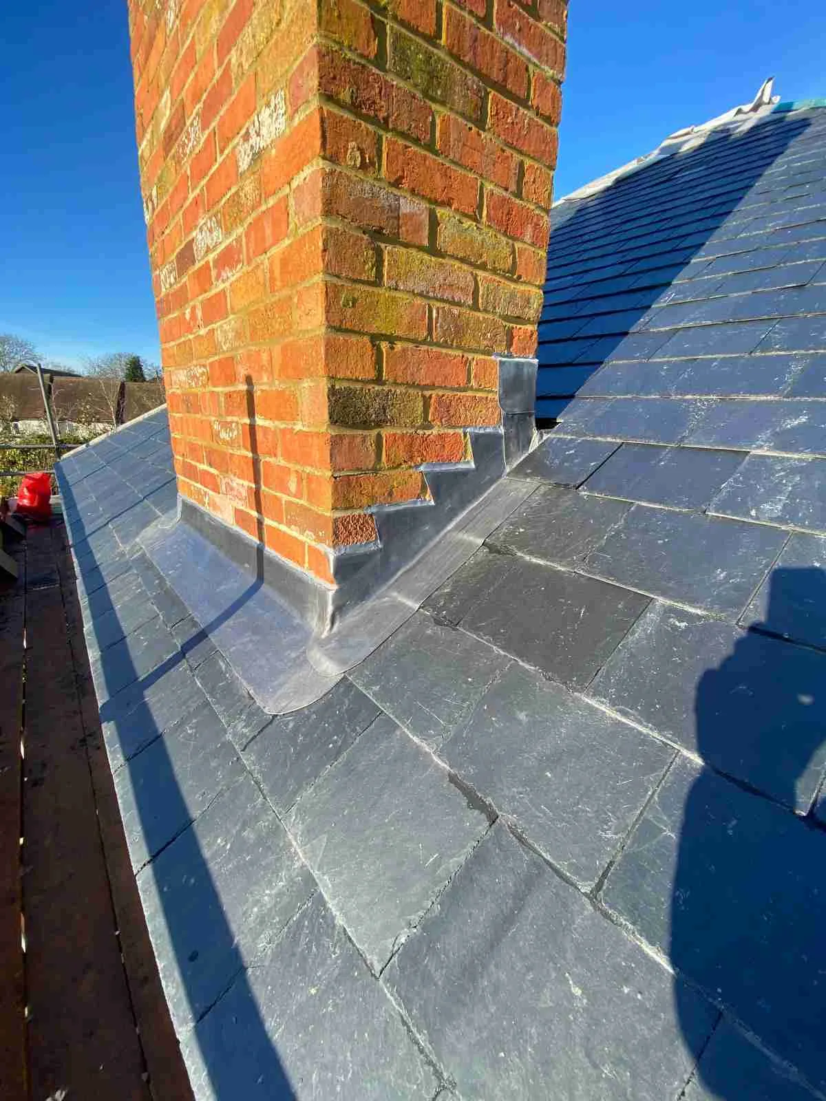 Lead flashing around a brick chimney on a slate roof